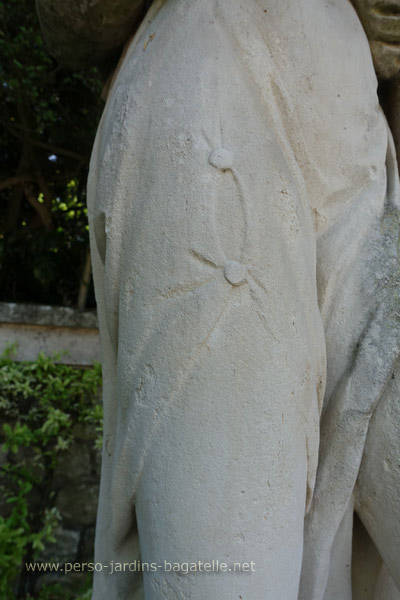 Détail de la première statue à gauche, deux boutons ronds refermant la tunique de la jeune femme en haut de la cuisse.