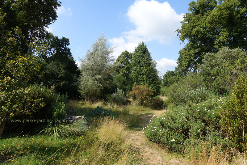 Entrée du jardin méditerranéen de Bagatelle, par le côté le plus proche du kiosque de l'Impératrice qui surplombe la roseraie.Un chemin  bordé l'arbustes méditerranéens, de pins, ...