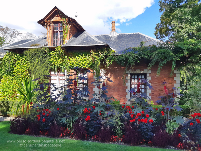 La maison du chef jardinier , avec des dahlias rouges