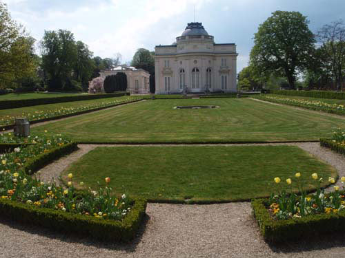 Chateau et Jardin français bordé de tulipes. Au fond, le trianon et ses magnolias fleuris